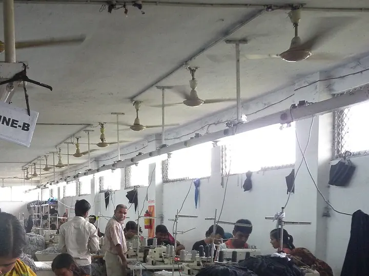 A garment factory floor with rows of sewing machines